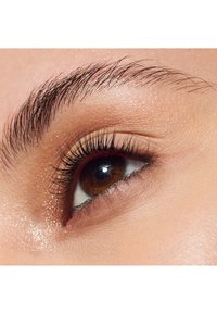 Close-up van een bruine oog met lange, donkere wimpers, een gladde huidtextuur rond het ooglid en een subtiele glans op het ooglid.