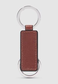 Portachiavi rettangolare in pelle marrone con due anelli di metallo argentati, su uno sfondo grigio chiaro.