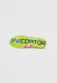 Predator soccer cleat featuring a bright pink and green color scheme, textured grip surface, and a distinct black logo on the sole.