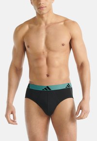 Czarne bokserki z turkusową elastyczną talią ozdobioną czarnym logo. Wykonane z gładkiej tkaniny o dopasowanym kroju, zaprojektowane dla zapewnienia komfortu.