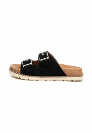 Sandalo in pelle scamosciata nera con due fibbie regolabili in argento, soletta beige morbida e suola in gomma chiara; presenta un design con bordo cucito.