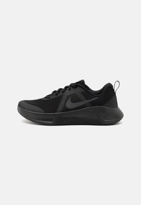 Schwarze Sportschuhe mit einem Obermaterial aus Mesh, gepolstertem Kragen und einer strukturierten Gummisohle. Das Design umfasst ein auffälliges Swoosh-Logo.