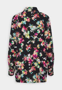 Floral blouse with a black background, featuring colorful flowers in pink, blue, and yellow. Long sleeves and a collared neckline.