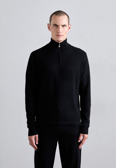 Pullover nero con zip al collo realizzato in tessuto morbido, dotato di maniche lunghe e una vestibilità aderente. Design minimalista con una silhouette elegante e una texture sottile.