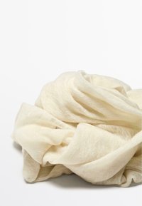 Letvægts beige tørklæde lavet af gennemsigtig, tekstureret stof, der har bløde, flydende folder og et delikat, luftigt udseende.