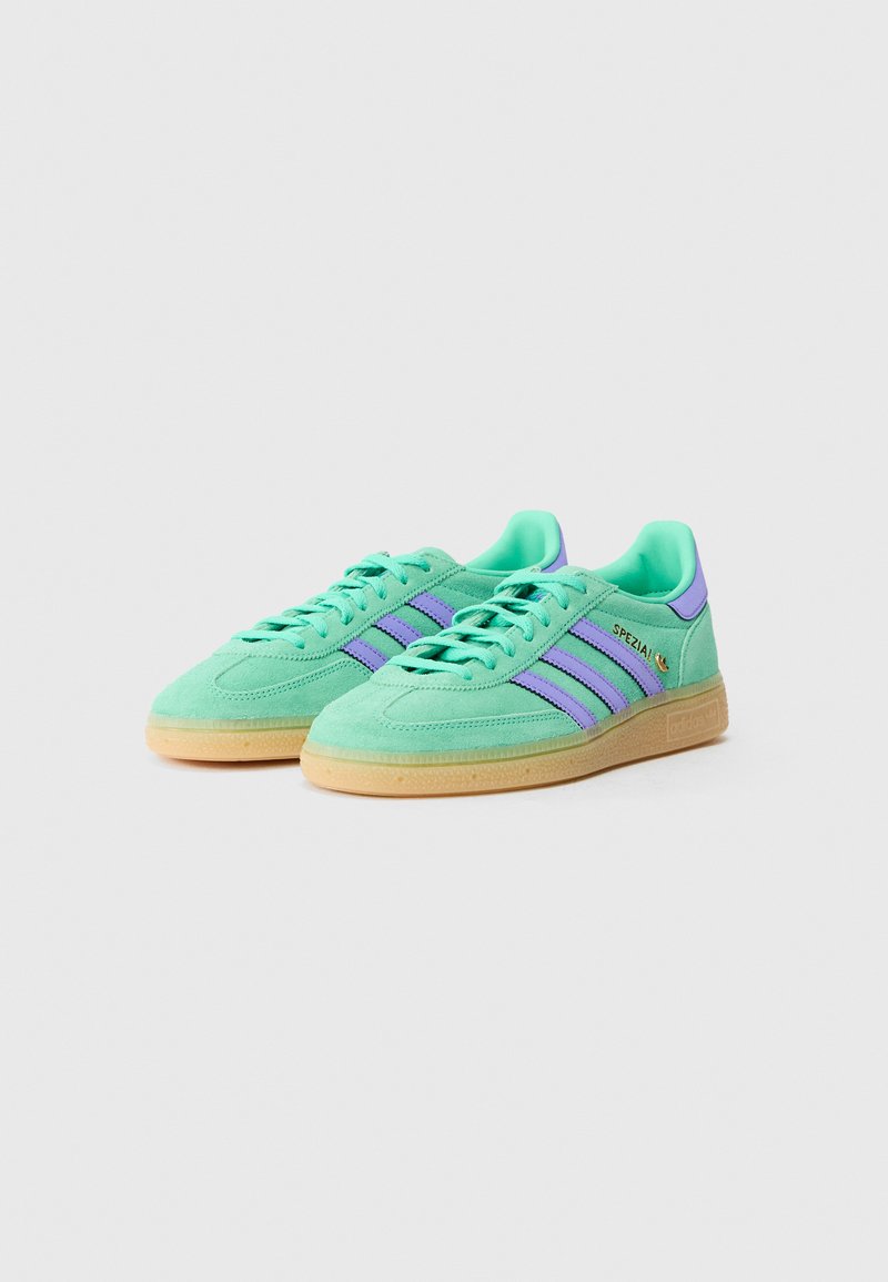 Green suede athletic shoes with purple stripes, round toe, flat gum rubber sole, and padded collar. Textured upper with lace-up design.