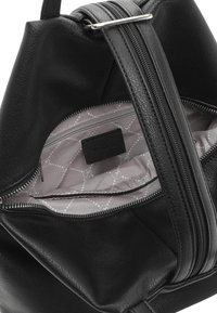 Schwarze Lederhandtasche mit glatter Textur, ausgestattet mit einem Reißverschluss und einem gemusterten hellgrauen Innenfutter, das über eine Reißverschlusstasche und ein Markenetikett verfügt.