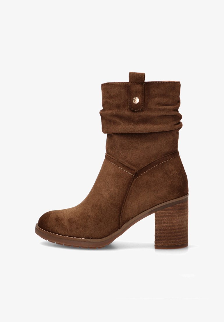 Botín de ante marrón hasta el tobillo con un eje doblado, punta redonda y tacón apilado. Presenta un botón decorativo y acentos de costura.