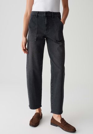 Black denim trousers with a relaxed fit, featuring side pockets, a high waist, and visible seam detailing. Paired with brown loafers.