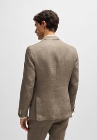 Light brown linen suit jacket with a notched collar, single vent, and four silver button accents on the sleeves. Subtle texture visible.