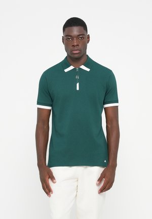 Groene polo met een gladde stof, voorzien van een ritssluiting bij de kraag, witte accenten op de halslijn en mouwen, en een slim fit ontwerp.