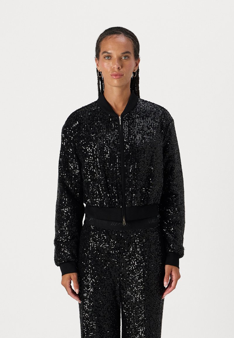 Black bomber jacket covered in sequins, featuring a zip front, ribbed cuffs, and hem. Smooth texture with reflective accents.