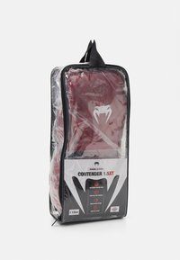 Crvene bokserske rukavice u pakiranju s prozirnom prednjom stranom. Imaju bijeli logo i crne naglaske, označene kao "Contender 1.5XT." Veličina 10 oz.