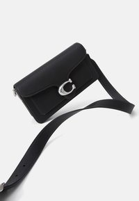 Borsa a tracolla nera in pelle con finitura testurizzata, chiusura a pattina e dettagli in metallo argentato. Dotata di una tracolla regolabile.