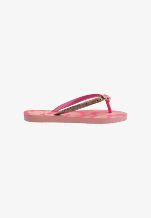 Rosa und beige Flip-Flops mit Blumenmuster auf der Sohle und glitzerndem rosa Riemen mit einer kleinen blumenförmigen Verzierung nahe dem Zehensteg.