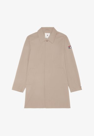 Cappotto beige fino al ginocchio con colletto a punta, maniche lunghe, tasche laterali e una patch con logo sulla manica sinistra. Texture liscia.