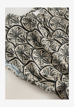 Leinenoberteil mit beigem Hintergrund und schwarzen botanischen Mustern, darunter Blätter und abstrakte Formen, mit einer leichten, strukturierten Oberfläche.
