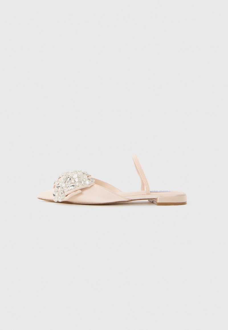 Beige flat sandal with open toe, slingback strap, and large clear rhinestone embellishments on the front strap.