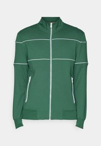 Giacca verde con zip in tessuto morbido. Caratterizzata da strisce orizzontali bianche e tasche laterali con zip. Collo alto e polsini aderenti.