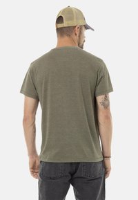 T-shirt olive à manches courtes avec col rond, coupe décontractée et tissu texturé. La vue arrière ne montre aucun motif ni insigne.