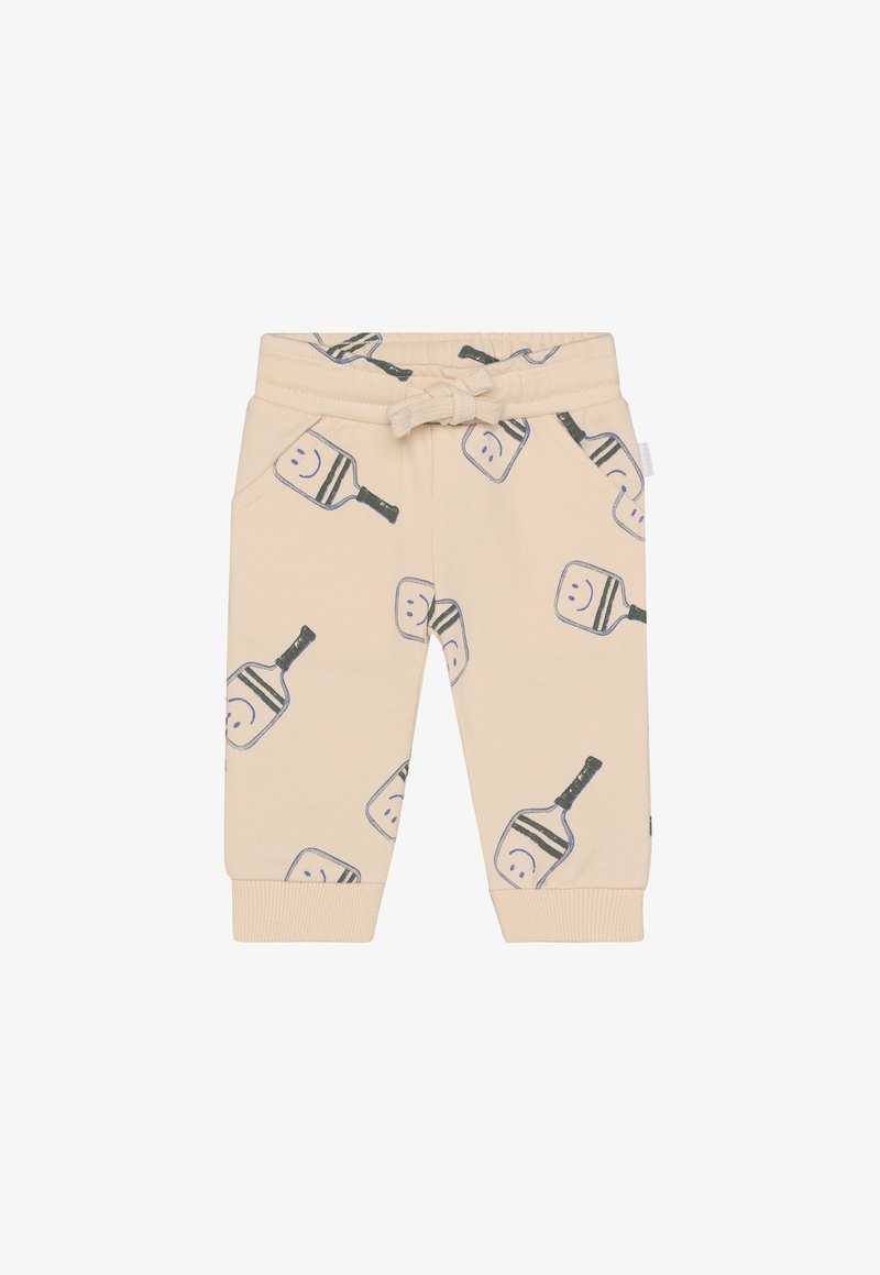 Pantalon jogger en coton beige avec un motif ludique de visages souriants et de petites pagaies, doté d'une ceinture élastique et de poches latérales.