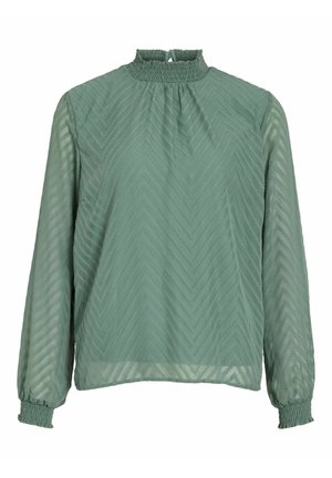 Blusa verde a maniche lunghe con colletto alto arricciato, motivo a zigzag testurizzato e polsini elasticizzati. Tessuto leggero e trasparente.