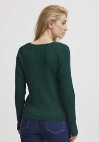 Maglione verde a coste con maniche lunghe, scollatura ampia e forma aderente. Motivo a maglia testurizzato e finitura del tessuto liscia.