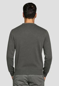 Dunkelgrauer Pullover mit Rundhalsausschnitt, gerippten Bündchen und Saum, weicher Strickstruktur und schlichtem Design. Verfügt über lange Ärmel und eine figurbetonte Silhouette.