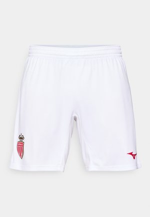 Valged spordilühikesed püksid elastse vöökohtaga, millel on punane aktsentlogo ja värviline embleem vasakul jalal. Sile ja hingav materjal.