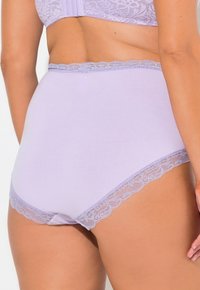 Slip di cotone lavanda con bordo in pizzo intricato lungo la vita e le aperture delle gambe, caratterizzato da una trama liscia e morbida.