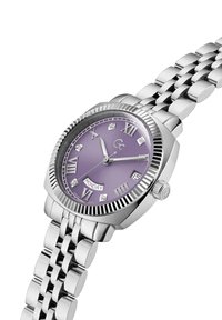 Srebrno-tonowa zegarek z żłobkowanym bezelem, purpurową tarczą, rzymskimi cyframi, wyświetlaczem daty oraz bransoletą z metalowych ogniw z polerowanymi linkami.