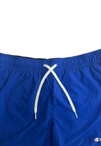 Pantaloni da bagno blu realizzati in materiale leggero con vita elastica, laccio bianco e un piccolo logo sul lato destro inferiore.