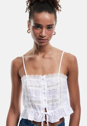Witte cropped top met een kant afgewerkt decolleté, knoopsluiting aan de voorkant en een gerimpelde onderkant. Gemaakt van een lichtgewicht, gestructureerde stof. Verstelbare bandjes.