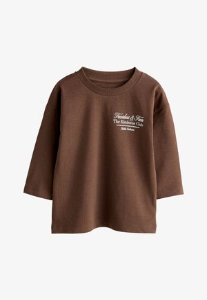 Brun langærmet sweatshirt lavet af bomuld. Har en ribbet rund hals og en hvid tekstgrafik på forsiden med "The Kindness Club."