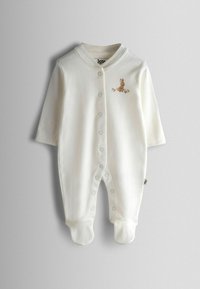 Valge puuvillane beebikombinesoon pika varrukaga, trukikinnitus, pruun tikandiga küülik rinnal ja jalad kaetud disainiga.