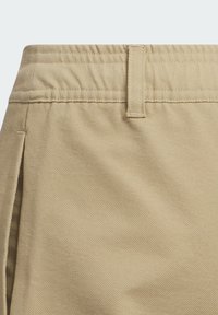 Pantalones cortos caqui con una textura suave, cinturilla plana, presillas para cinturón y bolsillos laterales. Presenta un corte recto y una tela duradera.