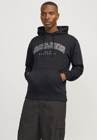 Hoodie noir en coton, avec une poche kangourou à l'avant, une capuche à cordon de serrage et un logo en texte blanc "JACK & JONES" sur la poitrine.