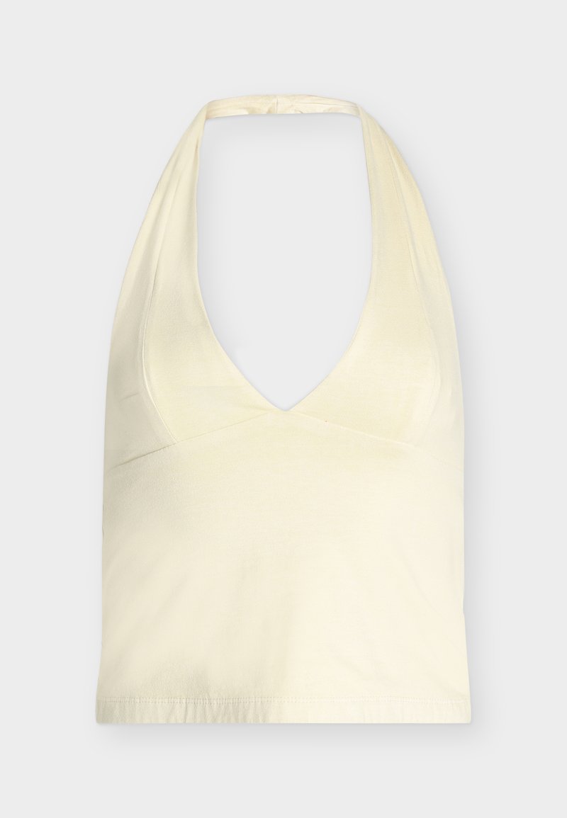 Κορυφή halter σε κρεμ απόχρωση με βαθύ V-λαιμόκοψη και φαρδιές τιράντες δεμένες στο πίσω μέρος, παρουσιάζεται πάνω σε απλό φωτεινό φόντο.