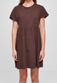 Hnědressové bavlněné šaty s krátkými rukávy a zaobleným výstřihem. Rozšířený spodek s nabíraným švem. Měkká textura a jednoduchý design.