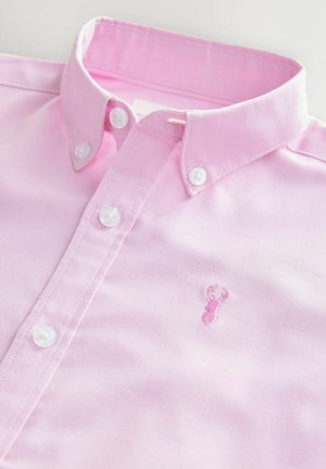 Chemise en coton rose clair à manches longues avec un col classique et des boutons blancs. Présente une petite broderie de homard rose sur la poitrine.