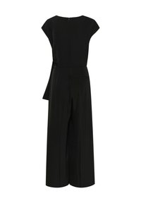 Combinaison noire avec une coupe à jambes larges, manches courtes, fermeture éclair dans le dos et un détail noué à la taille. Tissu doux au toucher.