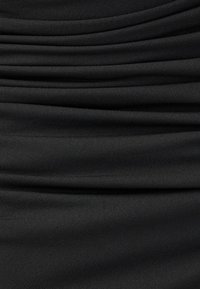 Schwarzer Stoff mit horizontalen Falten. Weiche Textur mit glatter Oberfläche. Das Material fällt elegant und erzeugt subtile Wellen.