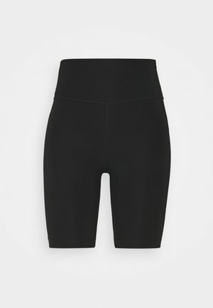 Short noir taille haute, longueur genou, ajusté avec coutures plates sur fond blanc uni.