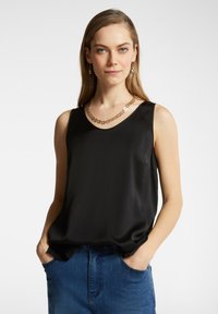 Top senza maniche in satin nero con scollatura a V, abbinato a una collana dorata con motivo floreale, forma semplice e texture liscia.