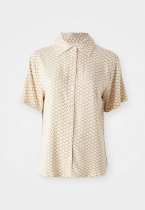 Kortermet, kragebluse i lys beige med hvit geometrisk mønster, med knappefront og myk, glatt tekstur.