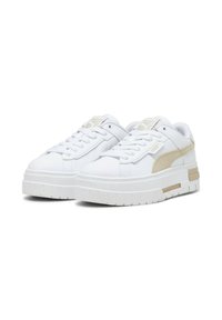 Zapatillas blancas con suela texturizada, que presentan un detalle en beige claro en el lateral y una lengüeta acolchada para mayor comodidad y soporte.