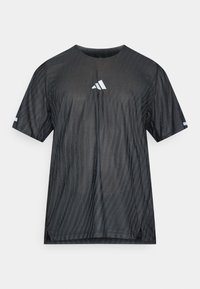 Musta lyhythihainen urheilupaita, jossa on kohokuvioitu vinoraitakuvio ja valkoinen Adidas-logo rinnassa ja hihoissa.