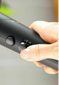 Zwarte handheld-apparaat met knoppen voor ventilator- en temperatuurregeling. Gladde textuur, ergonomisch ontwerp en zichtbare LED-indicatielampjes.