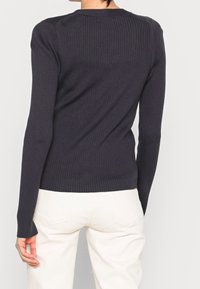 Maglione a coste grigio scuro con maniche lunghe e scollatura rotonda, visto da dietro. Texture morbida con un design aderente e dettagli di cucitura sottili.