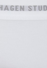 White elastic waistband with "Copenhagen Studios" logo in gray. Soft, smooth fabric texture. The overall design is minimalistic.